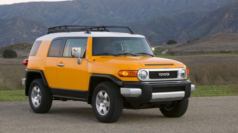 a yellow and white suv parked in a parking lot.