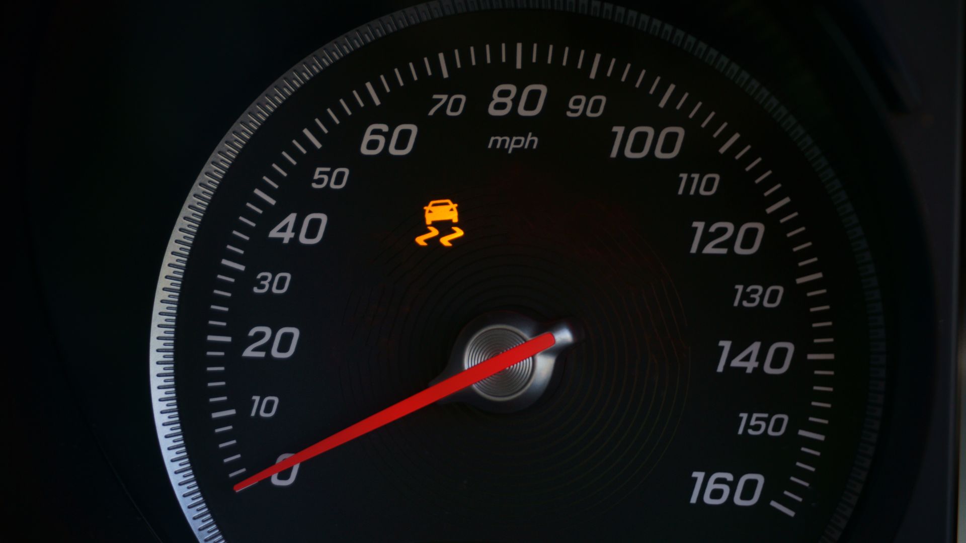 a close up of a speedometer with a red needle.