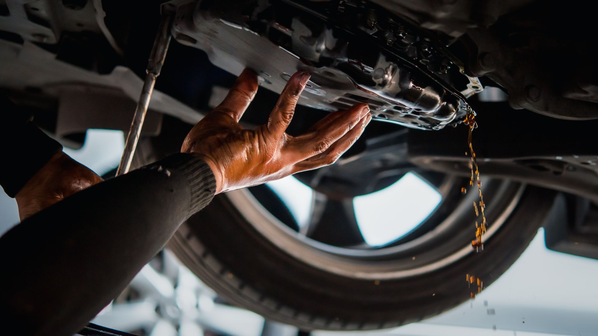 a man is working on a car under the tire.