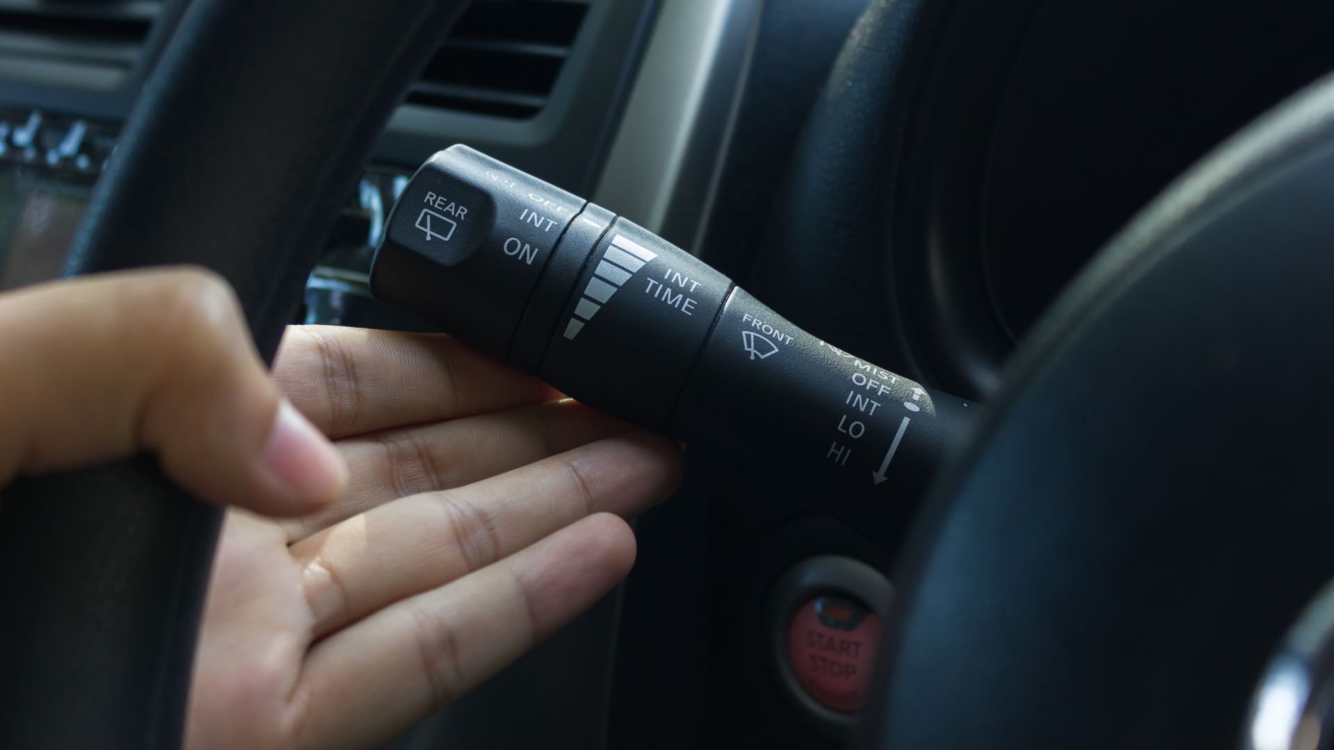 a person is holding the steering wheel of a car.