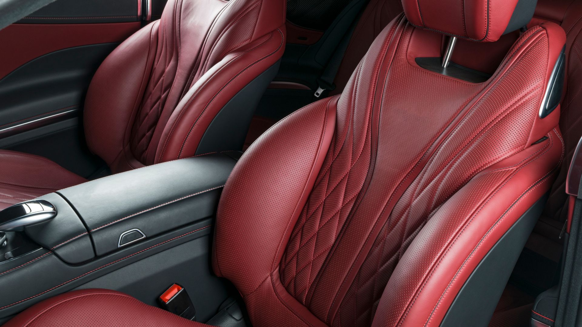 the interior of a car with red leather seats.