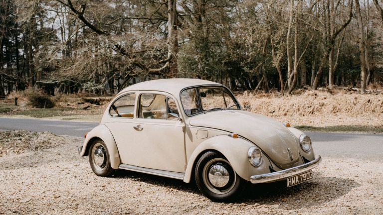 an old vw bug parked on the side of the road.