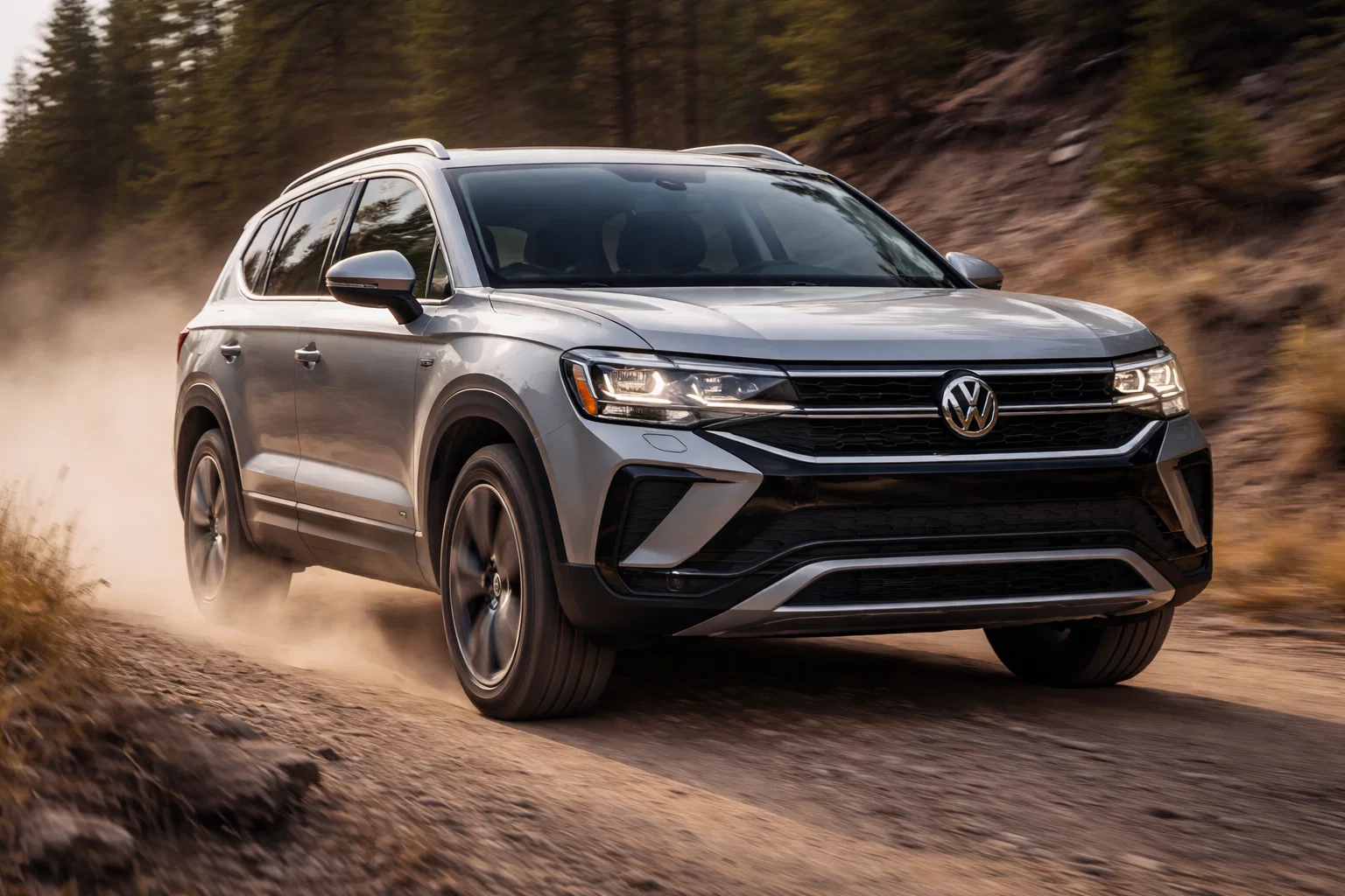 A silver VW Taos SUV drives on a dusty, unpaved road through a forested area with trees in the background.