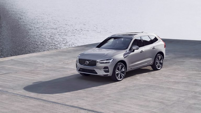 a silver volvo suv parked near a body of water.