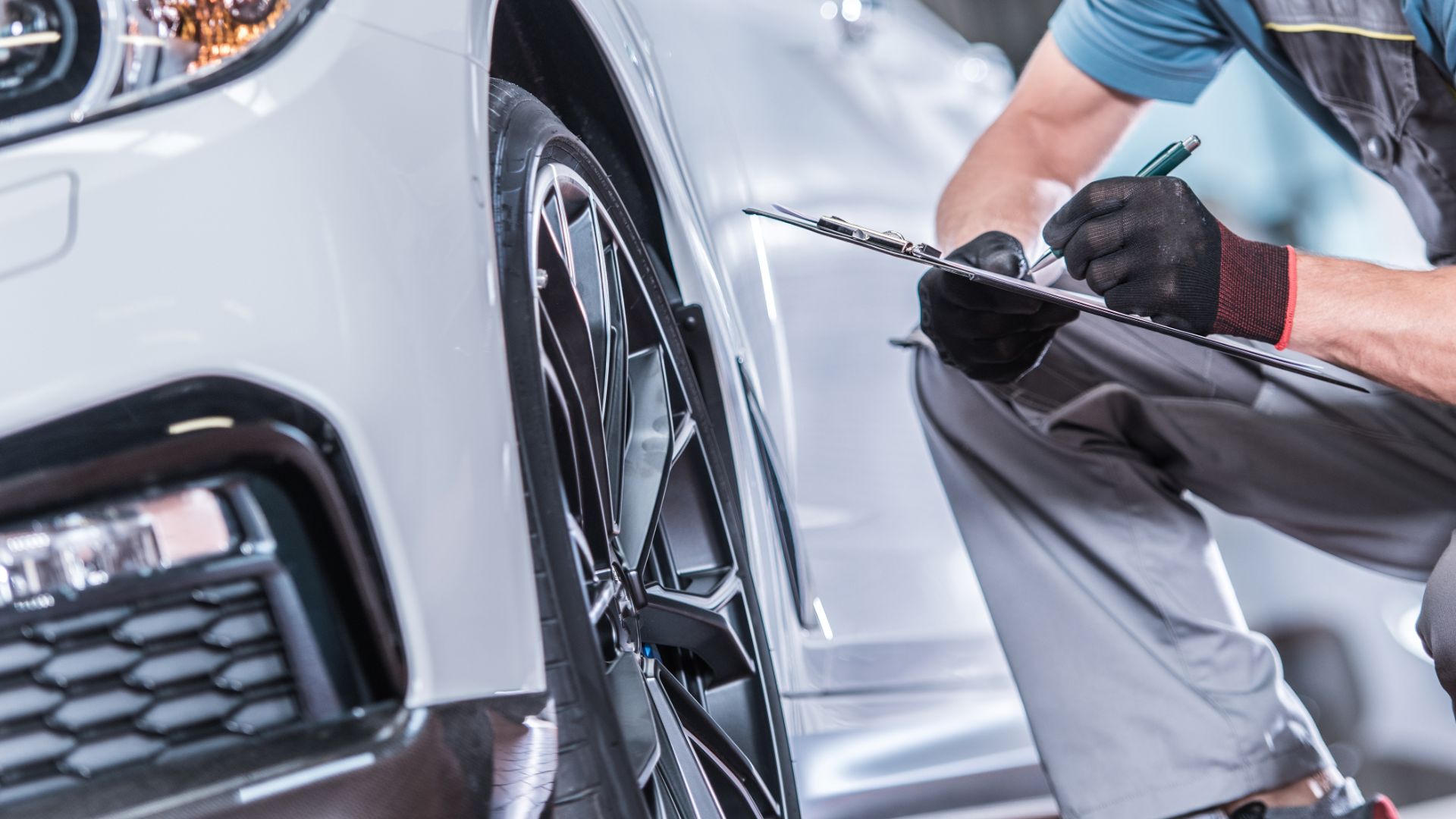 a man working on a car with a wrench.