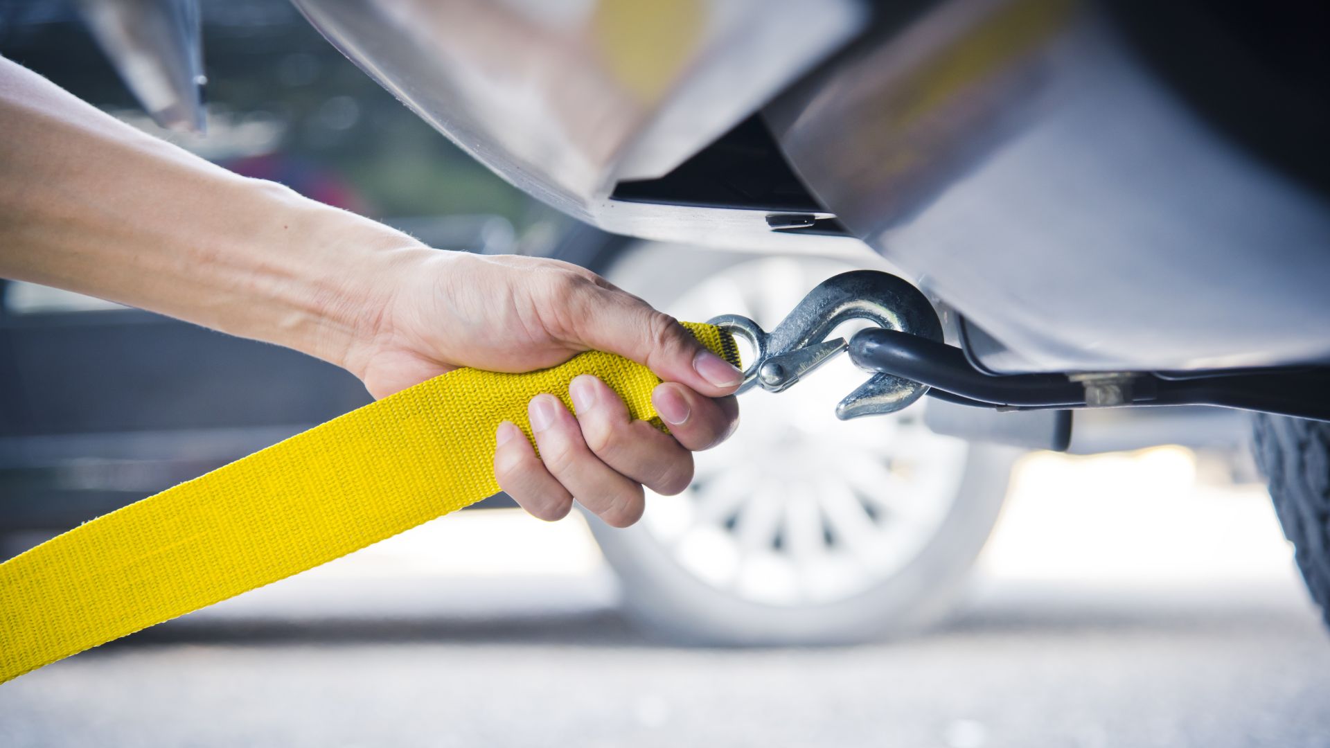 a person holding a wrench to a yellow hose.