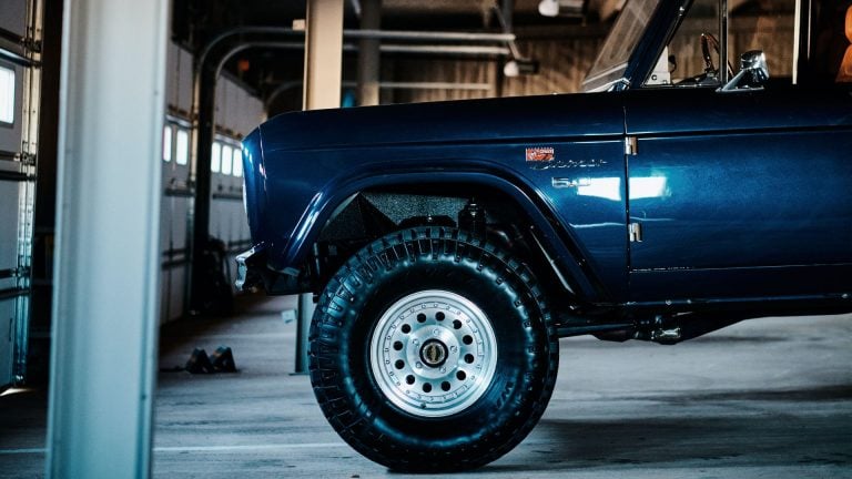 a blue truck parked inside of a garage.