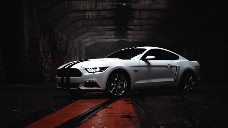 a white car parked in a dark tunnel.